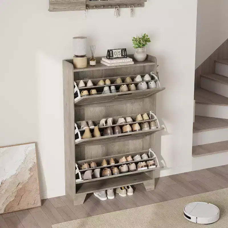 Meuble à chaussures autoportant avec 3 portes basculantes. Rangement dissimulé pour entrée, peut contenir plusieurs paires, style ferme avec crochets latéraux.