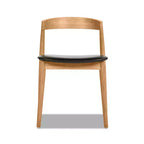 Chaise de salle à manger empilable Raven 20.5 en bois de chêne sculpté, brun naturel chaud et revêtement en similicuir noir